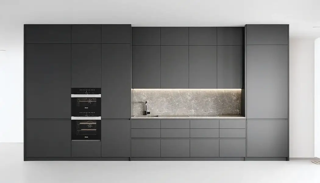 Primera imagen de la galería CASTAU: cocina con frentes oscuros, muebles superiores claros y salpicadero veteado